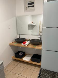 a bathroom with two sinks on a wooden counter at O Soleya in Saint-Joseph