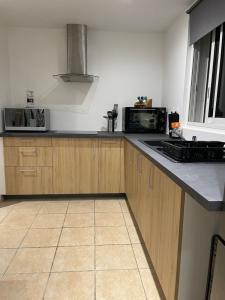 a kitchen with wooden cabinets and a black counter top at O Soleya in Saint-Joseph +13 photos