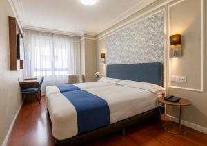 Postel nebo postele na pokoji v ubytování Hotel Corona de Castilla Burgos