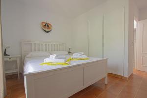 a bedroom with a white bed with towels on it at Marina de Casares Beach House in San Luis de Sabinillas