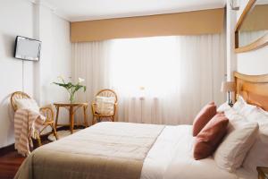 Un dormitorio con una cama grande y una ventana. en Motel Bambú, en Lugo