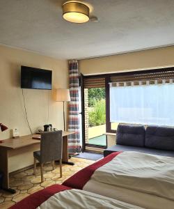 a hotel room with a bed and a desk and a window at Haus Scheuten Hotel in Duisburg