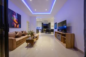 a living room with a couch and a tv at Thala Villa Koh Samui in Nathon Bay