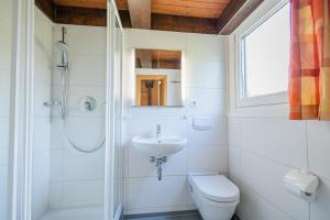 a white bathroom with a sink and a toilet at Ferienwohnpark Immenstaad am Bodensee Nurdachhaus Typ 8 in Immenstaad am Bodensee +19 photos