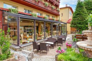 patio z krzesłami i stołami przed budynkiem w obiekcie Hotel Pod Szrenicą w Szklarskiej Porębie
