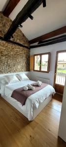 a bedroom with a large bed in a brick wall at Casa cerca de Cabárceno en Parque Natural de Peña Cabarga in Liérganes
