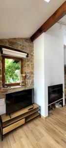 a living room with a fireplace and a television at Casa cerca de Cabárceno en Parque Natural de Peña Cabarga in Liérganes