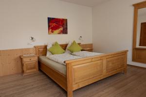 una camera con letto in legno e cuscini verdi di Prestihof a San Vigilio Di Marebbe