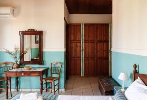 a room with a table and chairs and a mirror at AMNISIADES APARTMENTS in Karteros