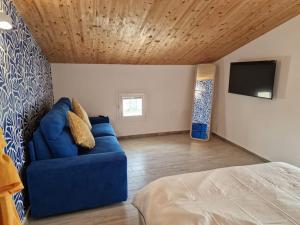 a living room with a blue couch and a tv at Casa del Sole Marzamemi Borgo 84 in Marzamemi