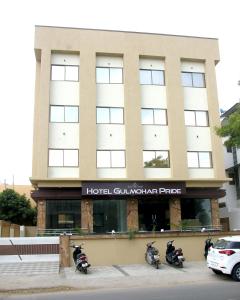 Hotel Gulmohar Pride في أحمدناغار: مجموعة من الدراجات النارية متوقفة أمام المبنى