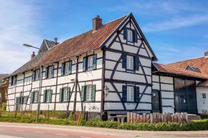 Un edificio blanco y negro con persianas verdes. en BnB Het Geluk van Limburg, en Mechelen