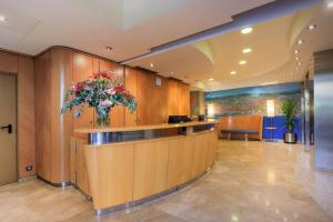 a lobby with a vase of flowers on a counter at Hotel del Mar in Barcelona
