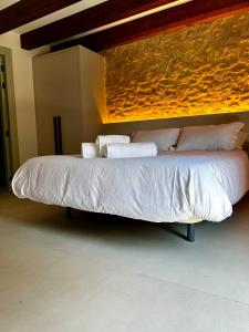a bed with white sheets and pillows in a room at Hotel Rural Casa Nardo in Dobro +9 photos