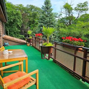a balcony with green flooring and a table and chairs at Haus Scheuten Hotel in Duisburg