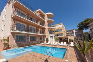 an apartment with a swimming pool in front of a building at Martinez Apartments in Palmanova +17 photos