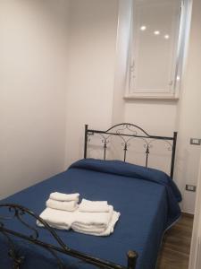 a bedroom with a blue bed with towels on it at Terracina Holiday Succursale in Terracina
