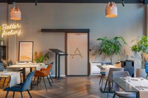 a restaurant with tables and chairs and a sign on the wall at Hotel A'mare in Zadar