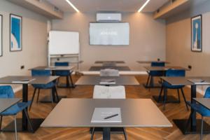 a classroom with tables and chairs and a whiteboard at Hotel A'mare in Zadar