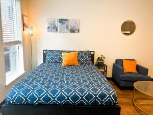 a bedroom with a bed and a chair at Ballpark Spruce Studio in Saint Louis
