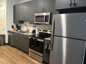 a kitchen with a stainless steel refrigerator and a microwave at Ballpark Spruce Studio in Saint Louis