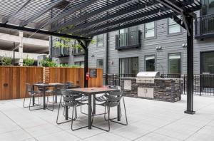 a patio with tables and chairs and a grill at Ballpark Spruce Studio in Saint Louis