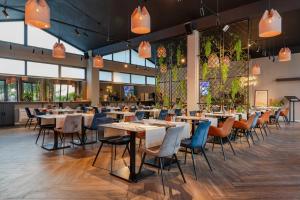 ザダルにあるHotel A'mareのテーブルと椅子と窓のあるダイニングルーム