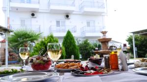 una tavola con piatti di cibo e bicchieri di vino di Bar Restorant Hotel Rama a Belsh