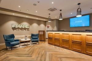 a waiting room with chairs and a counter and a tv at Hotel A'mare in Zadar