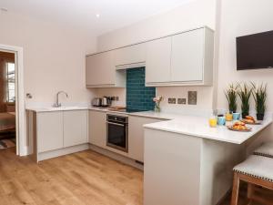 a kitchen with white cabinets and a counter top at 1 Sea Otter House in Teignmouth +19 photos