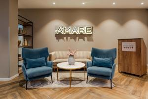 a waiting room with two blue chairs and a table at Hotel A'mare in Zadar