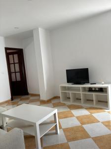 Una sala de estar con un televisor y una mesa blanca. en Asís 20.7, en Medina Sidonia 5 fotos más