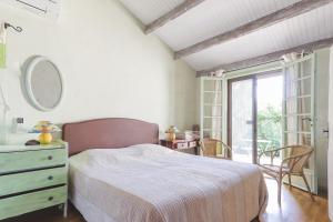 a bedroom with a bed and a dresser and a window at Les Oliviers in Saint-Maximin