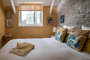 a bedroom with a large bed with a stone wall at Zen Den Cornwall in Boscastle