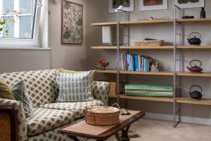 a living room with a couch and a table at Zen Den Cornwall in Boscastle