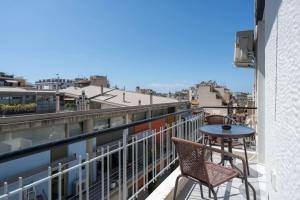 a balcony with a table and chairs on a building at Revived Urban Charm - 1BR in Athens