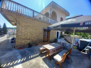 a patio with a table and chairs and an umbrella at Ulpiana - Apartments,Rooms,Hostel in Ulcinj +46 photos