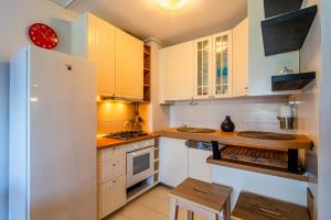 a kitchen with white cabinets and a white refrigerator at Flexible SelfCheckIns 92 - Zagreb - Parking - Loggia - Bedroom in Zagreb