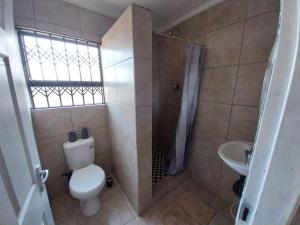 a bathroom with a toilet and a shower and a sink at khutsong Apartments in Secunda