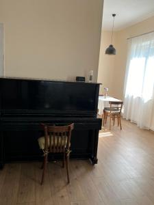 a black piano in a living room with a table at Duplex in Arinj in Arrinj