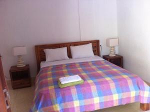 a bedroom with a colorful bed with two lamps at Amed Sari Beach Guesthouse in Amed