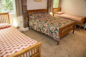 a bedroom with two beds and two windows at Hillside House in Chester