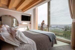 瓦尔多比亚德内Agriturismo Rive del Bacio - La Dimora的一间卧室，里面有一张床和一扇大窗户。