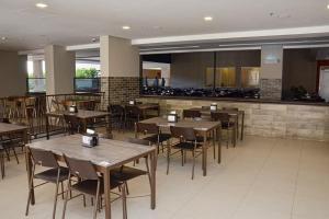restauracja z drewnianymi stołami i krzesłami oraz kuchnią w obiekcie Enjoy Olimpia Park Resort, 2 quartos para até 8 pessoas w mieście Olímpia