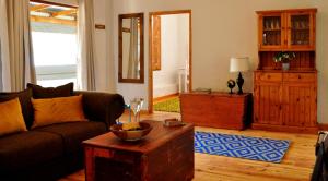 un salon avec un canapé et une table dans l'établissement Aloe Cottage, à Montagu