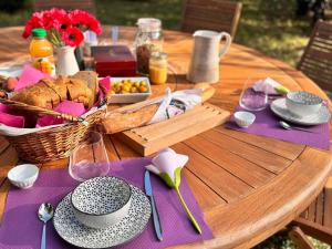 una mesa con una cesta de pan y una cesta de comida en La Chambre des Châteaux, en Cellettes 14 fotos más