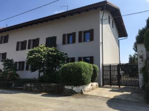 a white house with black windows and a fence at Il Girasole in Bricherasio