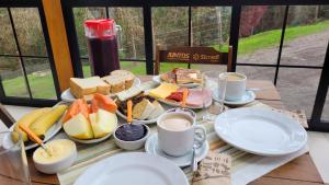 a table with plates of food and cups of coffee at Pousada Félix in Nova Petrópolis