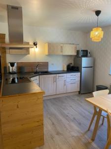 a large kitchen with wooden cabinets and a table at Loft 5 personnes type chalet avec jardin in Saint-Maurice-sur-Moselle