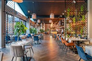 ザダルにあるHotel A'mareのテーブルと椅子と窓のあるダイニングルーム